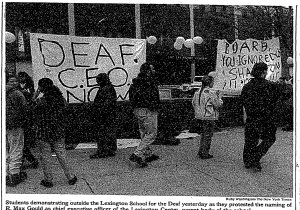 Protestors outside of a school holding signs. One says, &quot;Deaf CEO Now!&quot;